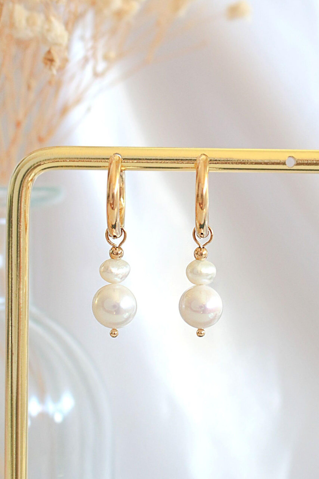 Elegant minimalist pearl earrings with delicate drops of genuine freshwater pearls and yellow gold-plated accents.