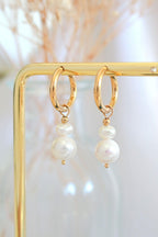 Minimalist pearl earrings featuring freshwater pearls and 24-karat yellow gold-plated stainless steel.